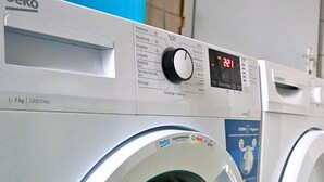 A front view of a front-loading washing machine with a digital display and control panel. - Le Gîte des Voyageurs  (Bourbourg)