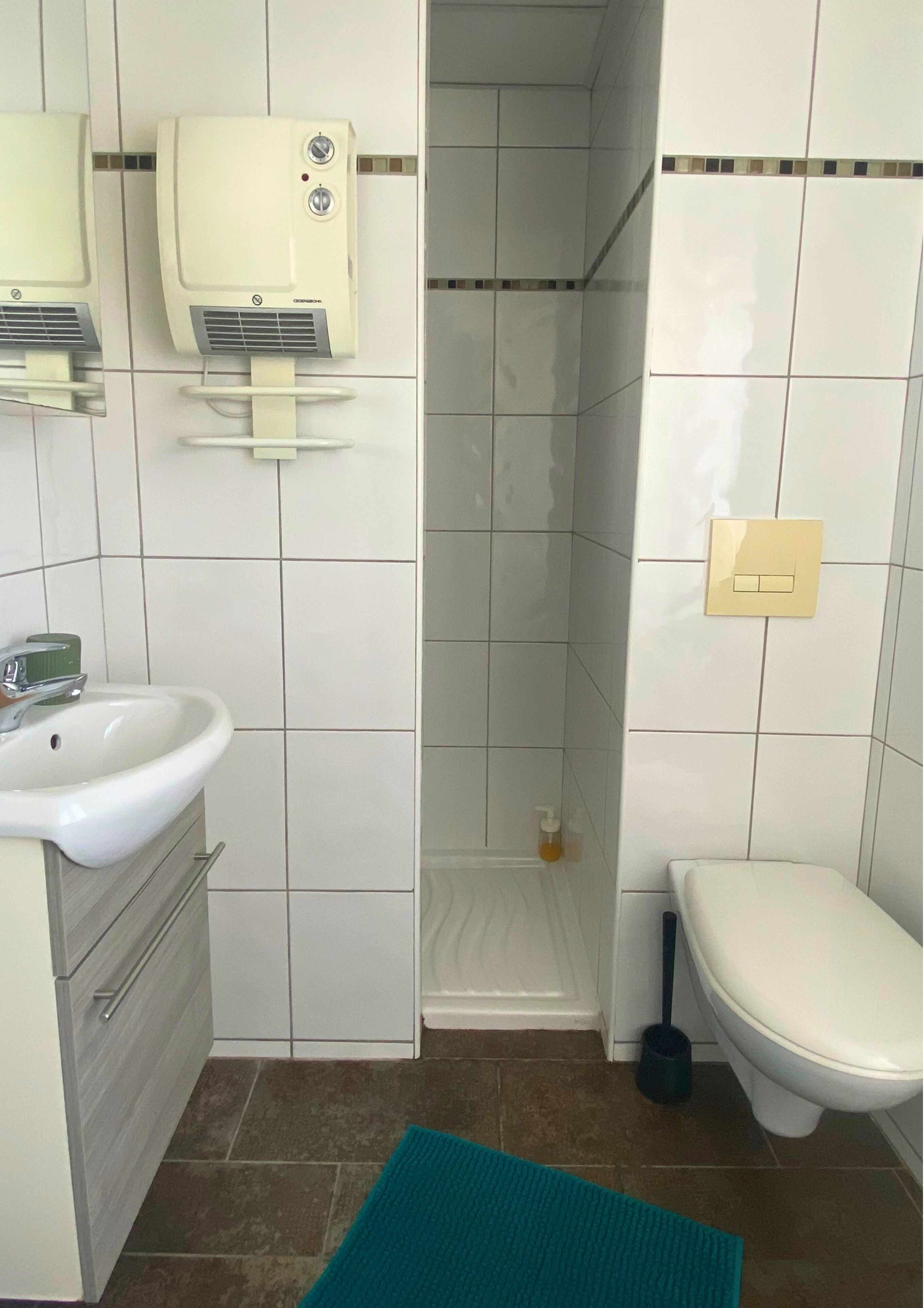 A bathroom with a sink, toilet, and shower.