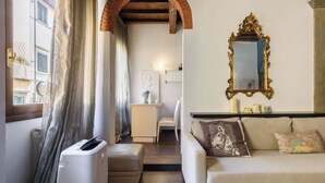 A living room with a sofa, a coffee table, a fireplace, and a large mirror. - Borgo Art Apartment by Mmega (Florence)