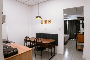 Uma cozinha compacta com área de refeições, uma pequena geladeira e um toca-discos.