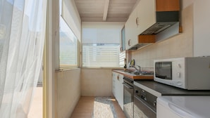 A compact kitchen with a microwave, stove, and oven. - Terrazza Corallo by Wonderful Italy (Bari)