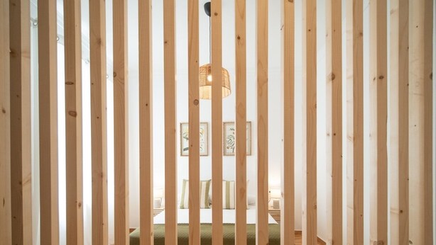 A room with a bed, a hanging light fixture, and a framed picture on the wall. - SibsSanlucar Duquesa - Ideal Parejas (Sanlúcar de Barrameda)
