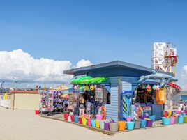 Un quiosco en la playa con equipo de playa colorido y juguetes inflables.