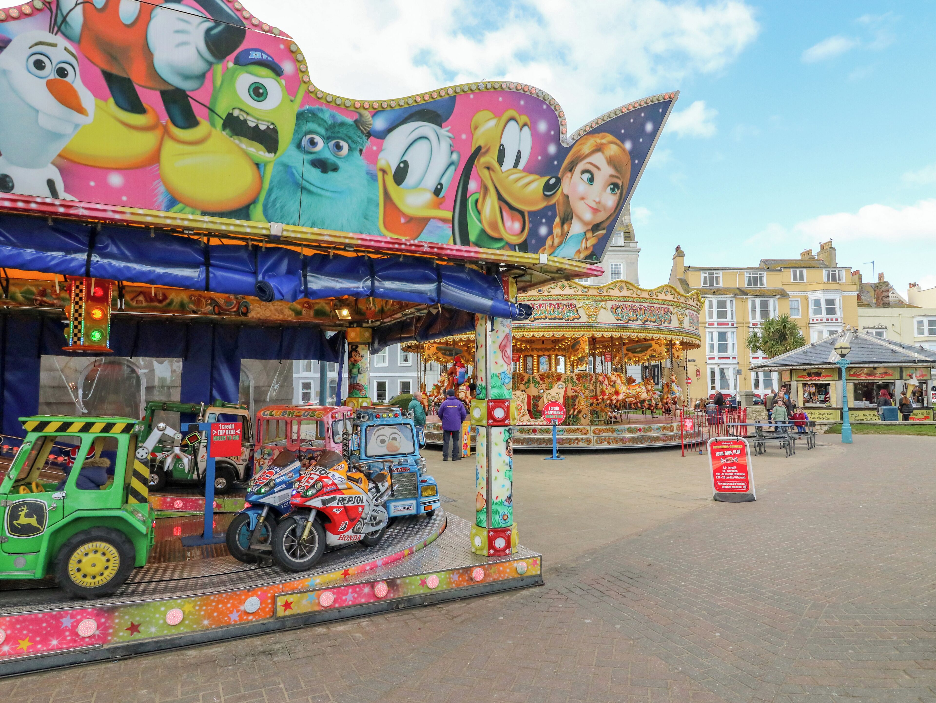 A carousel with colorful decorations and a signboard.