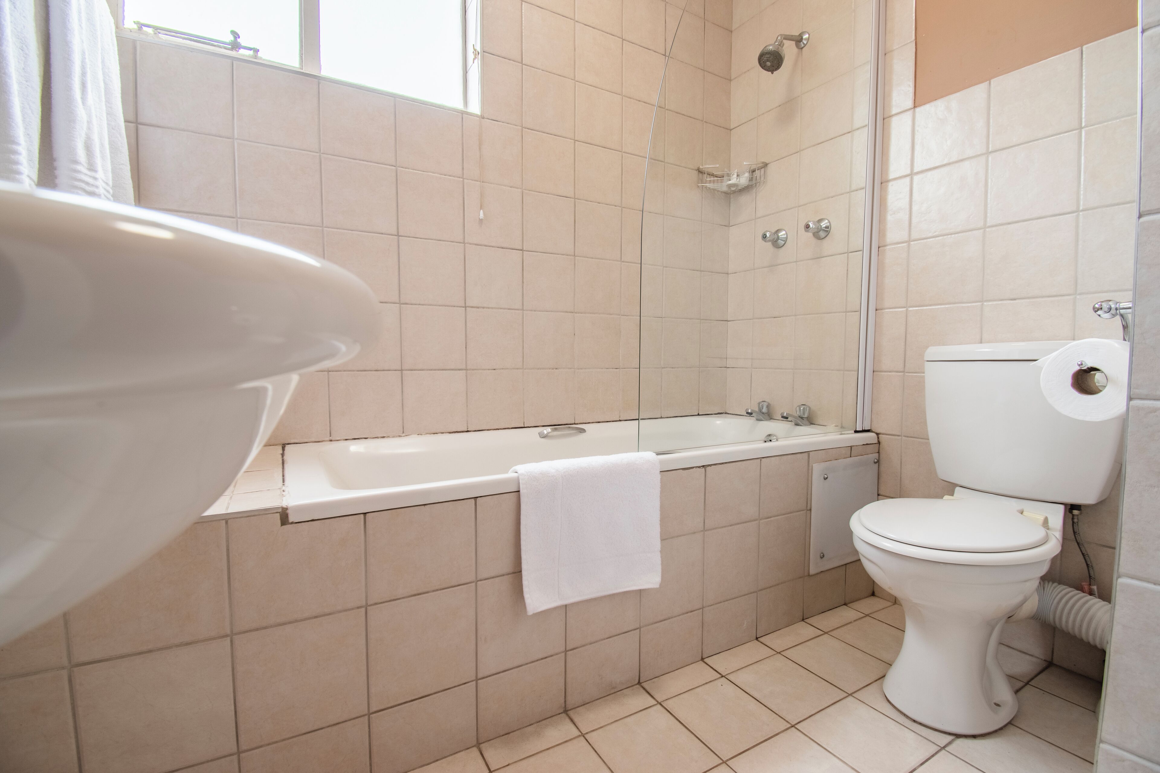 A bathroom with a bathtub, toilet, and shower.