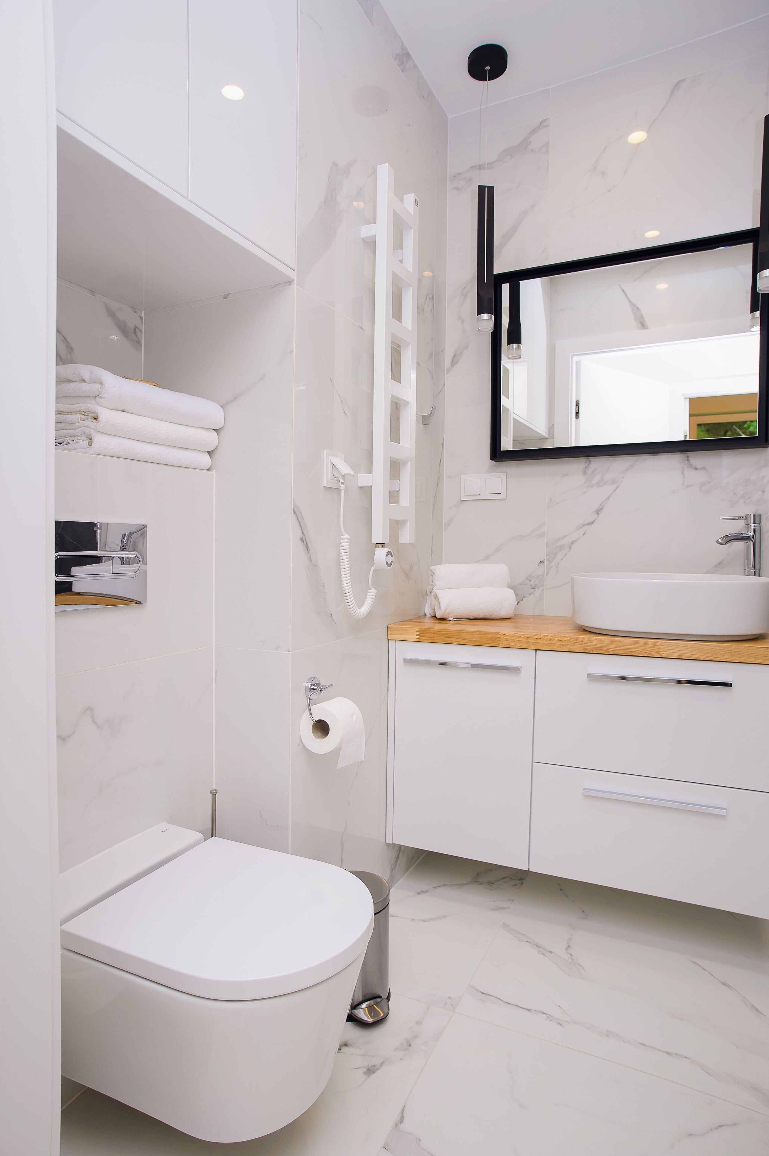 A modern bathroom with a toilet, sink, and shower.