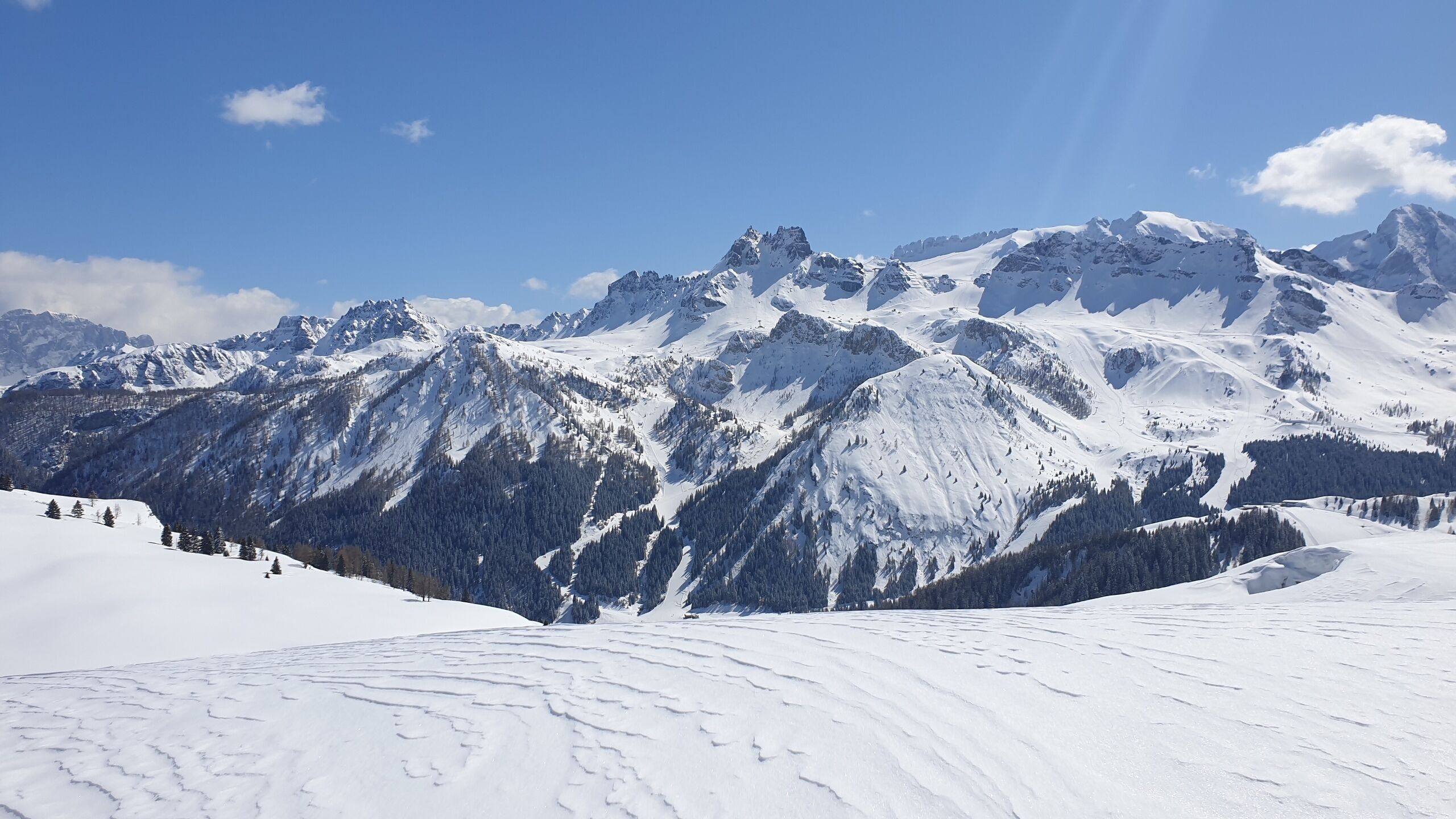 Un paisaje montañoso cubierto de nieve con cielos despejados.