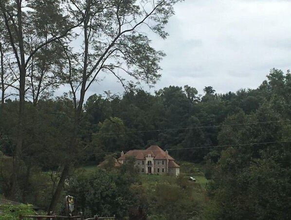 A large, historic building surrounded by dense forest. - Sugarland Farmhouse (Morgantown)
