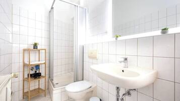 Ein Badezimmer mit Dusche, Toilette und Waschbecken.