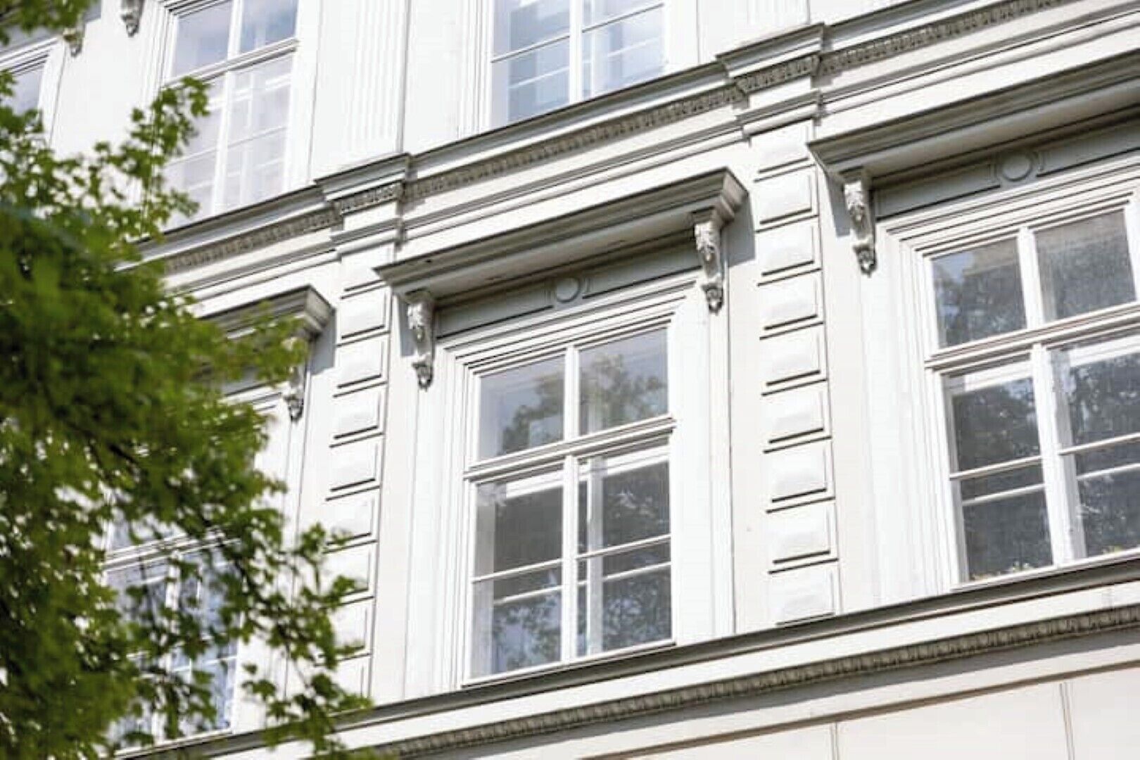 Eine auffällige Fassade mit großen Fenstern und klassischer Architektur.