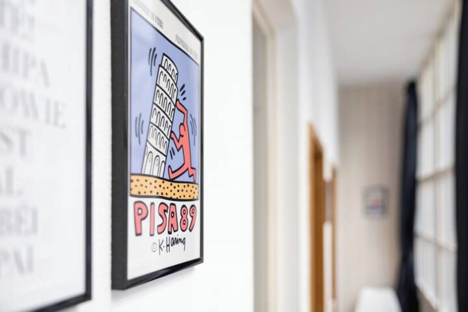 A framed artwork of the Leaning Tower of Pisa with the text "PISA89" and a signature.