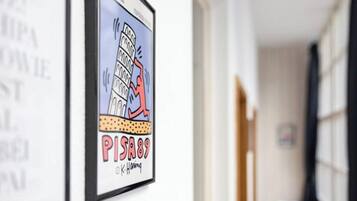 A framed artwork of the Leaning Tower of Pisa with the text "PISA89" and a signature.