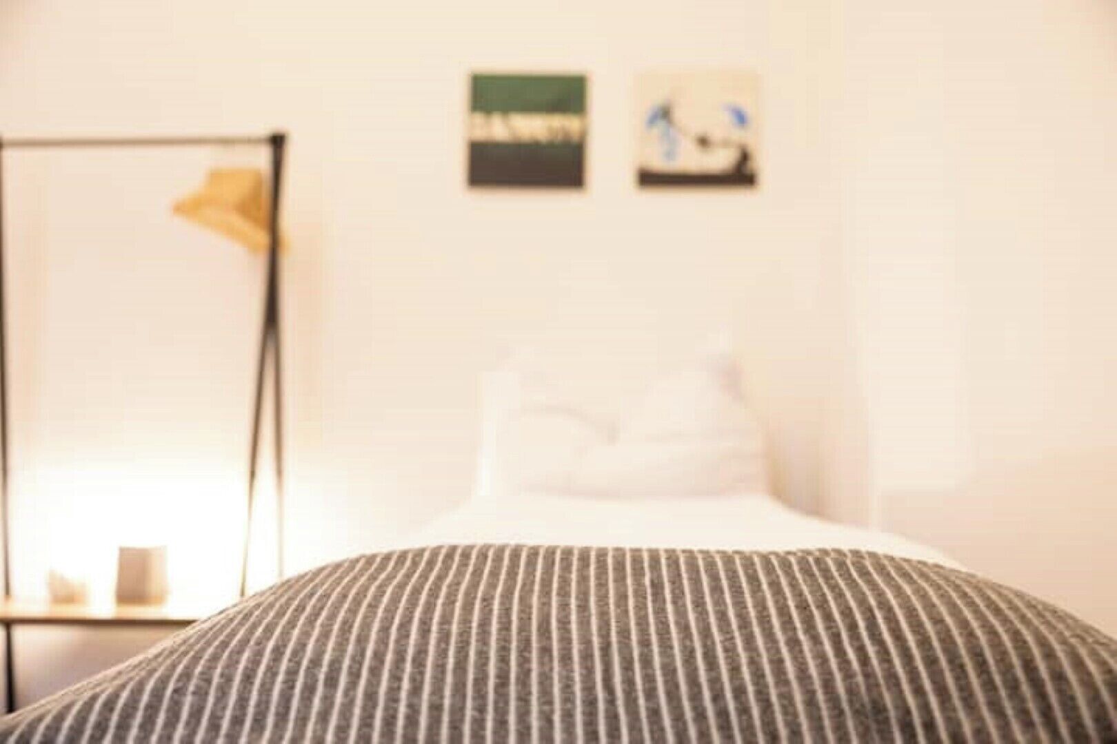 Una habitació d'hotel amb un llit, una taula de nit i una estantanya penjada a la paret.