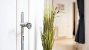 A white door with a silver handle and a lock.
