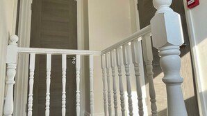 A staircase with white balusters and a white handrail leading to a landing. - Trendy Apartment in The City - Shoreditch (London)