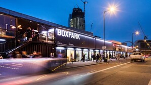 A modern BOXPARK building with a prominent entrance, outdoor seating, and a staircase leading to an upper level. - Cosy En-suite in The City - Shoreditch (London)