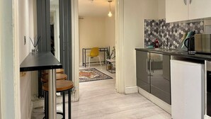 Una cocina moderna con comedor, una pequeña mesa con taburetes y una isla de cocina.