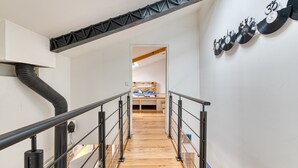 Ein modernes Interieur mit einer Holztreppe, Metallgeländern und einem wandmontierten Plattenspieler.