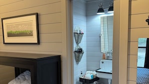 Une petite salle de bain comprenant un lavabo, un miroir et des étagères de rangement.