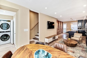 A modern apartment with a dining area, kitchen, and living space.