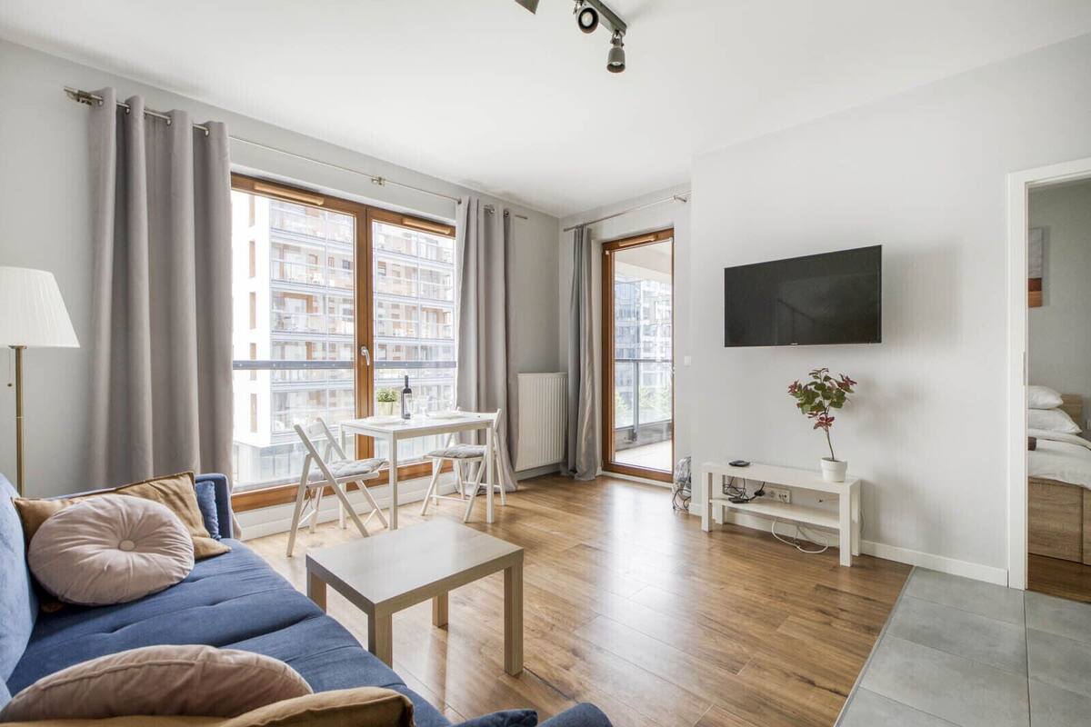 Een moderne woonkamer met een bank, een eettafel en een televisie.