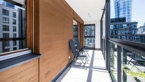 Un interior moderno con ventanas amplias, un muro decorativo de madera y vistas a un paisaje urbano.