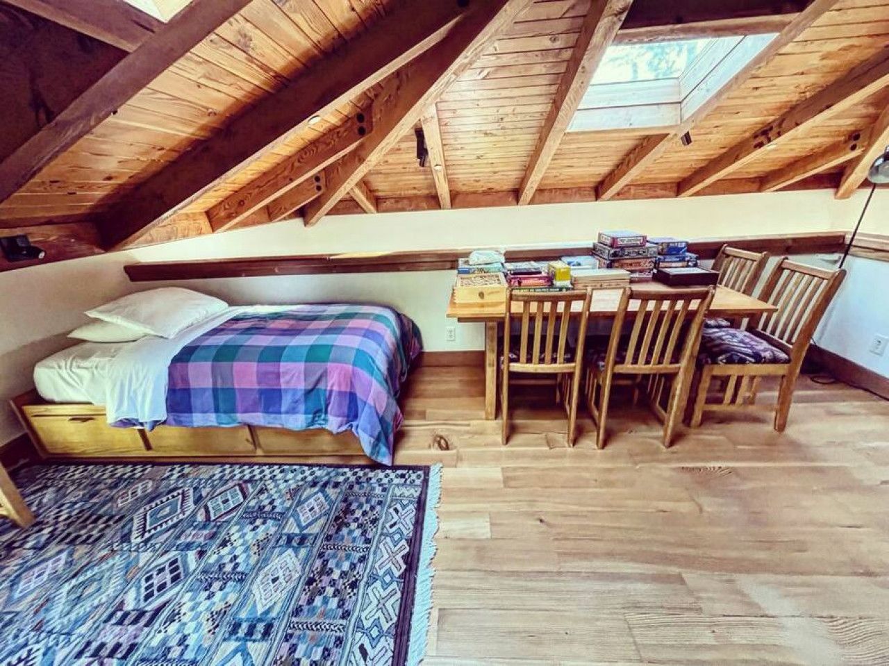 A loft bedroom with a bed, a desk, and a chair.