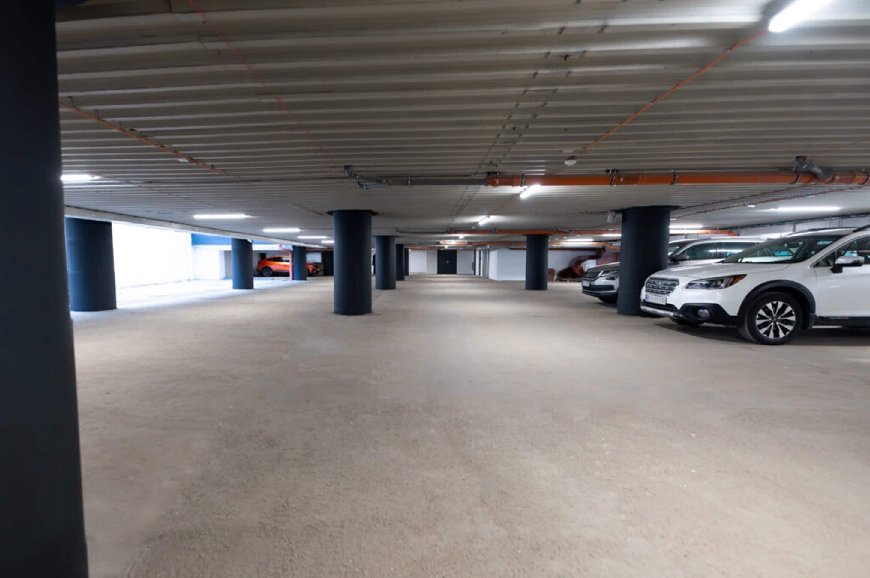 An indoor parking garage with multiple levels, concrete floors, and columns.