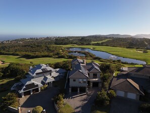 A residential area with houses, a golf course, and a body of water.