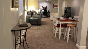 A compact living space with a dining area, a sofa, a small table, and a television.