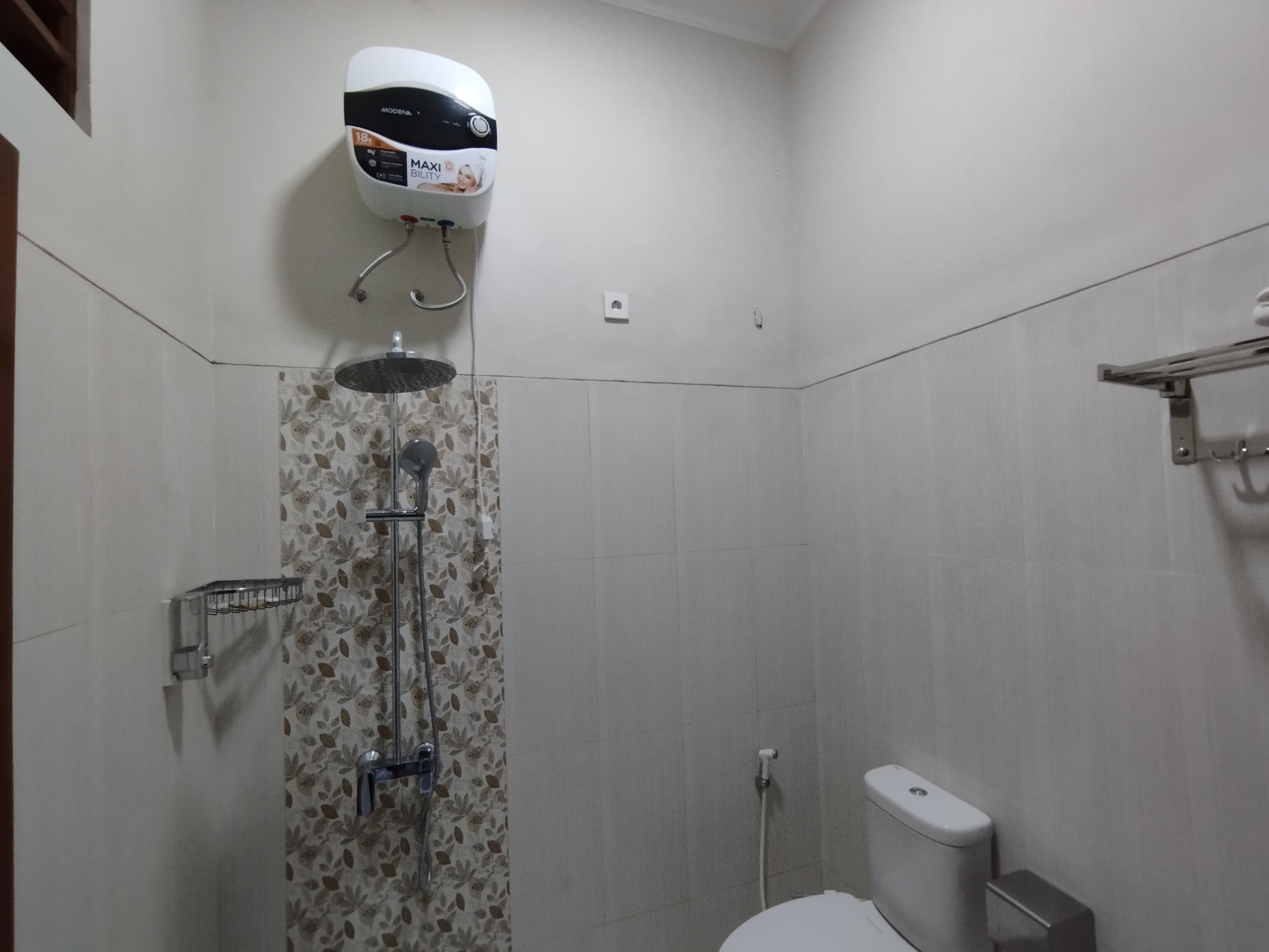 A bathroom with a shower, toilet, and a wall-mounted water heater.