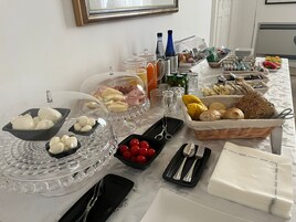 Una mesa de buffet con diversos alimentos, como pan, pasteles y frutas.