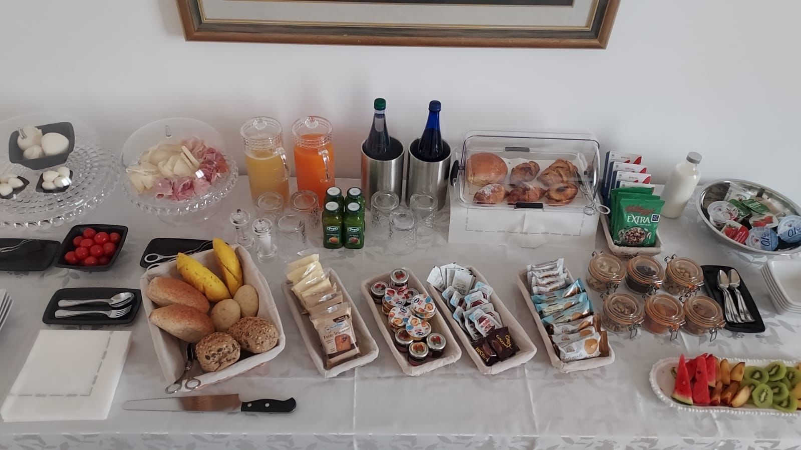 Una mesa de bufé con diversos alimentos, bebidas y salsas.