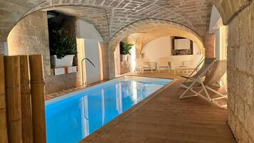 Una piscina techada, sillones reclinables de piscina