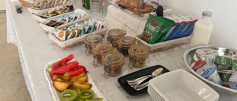 A breakfast buffet with various food items, including fruits, cereals, and beverages.