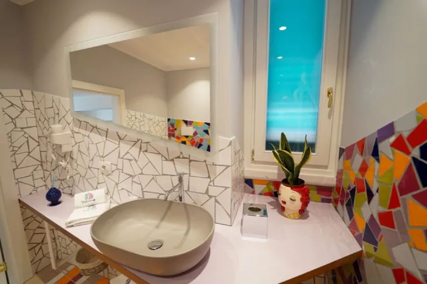 Un baño moderno con un lavamanos grande, un espejo y una ventana con vistas.