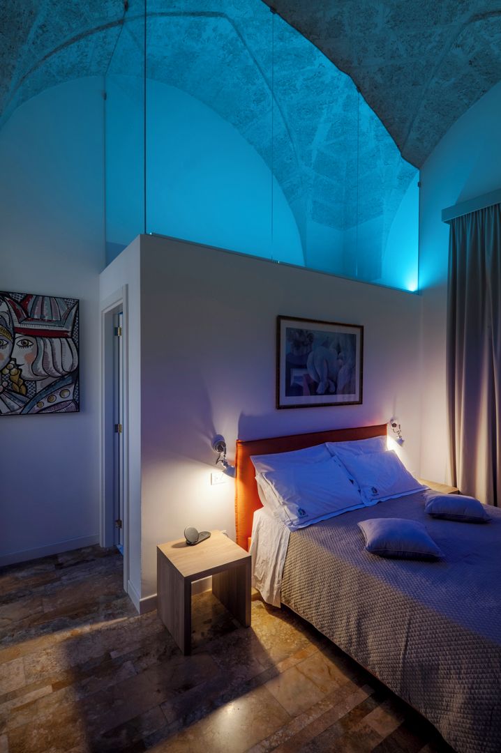 Une chambre à coucher avec un lit, une table de chevet et une œuvre d’art accrochée au mur.