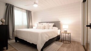 A bedroom with a bed, a bedside table, a lamp, and a nightstand. - Beautiful 5bedroom waterfront cottage with Hot Tub (South River)