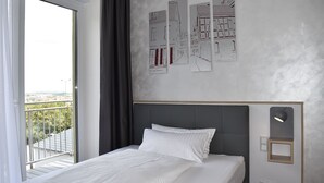 Een hotelkamer met een bed, uitzicht op de stad en kunst aan de muur.