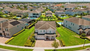 Un quartier résidentiel situé en périphérie, avec des maisons unifamiliales, des pelouses bien entretenues et une piscine centrale.