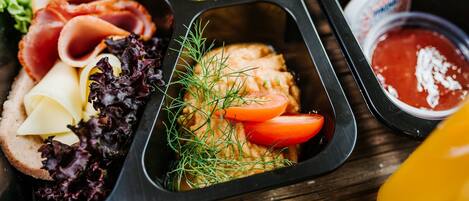 A meal tray with various food items including meats, cheese, and vegetables.