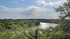 A river with surrounding greenery and a clear sky. - Quiet cabin on the Brazos
 (Graham)