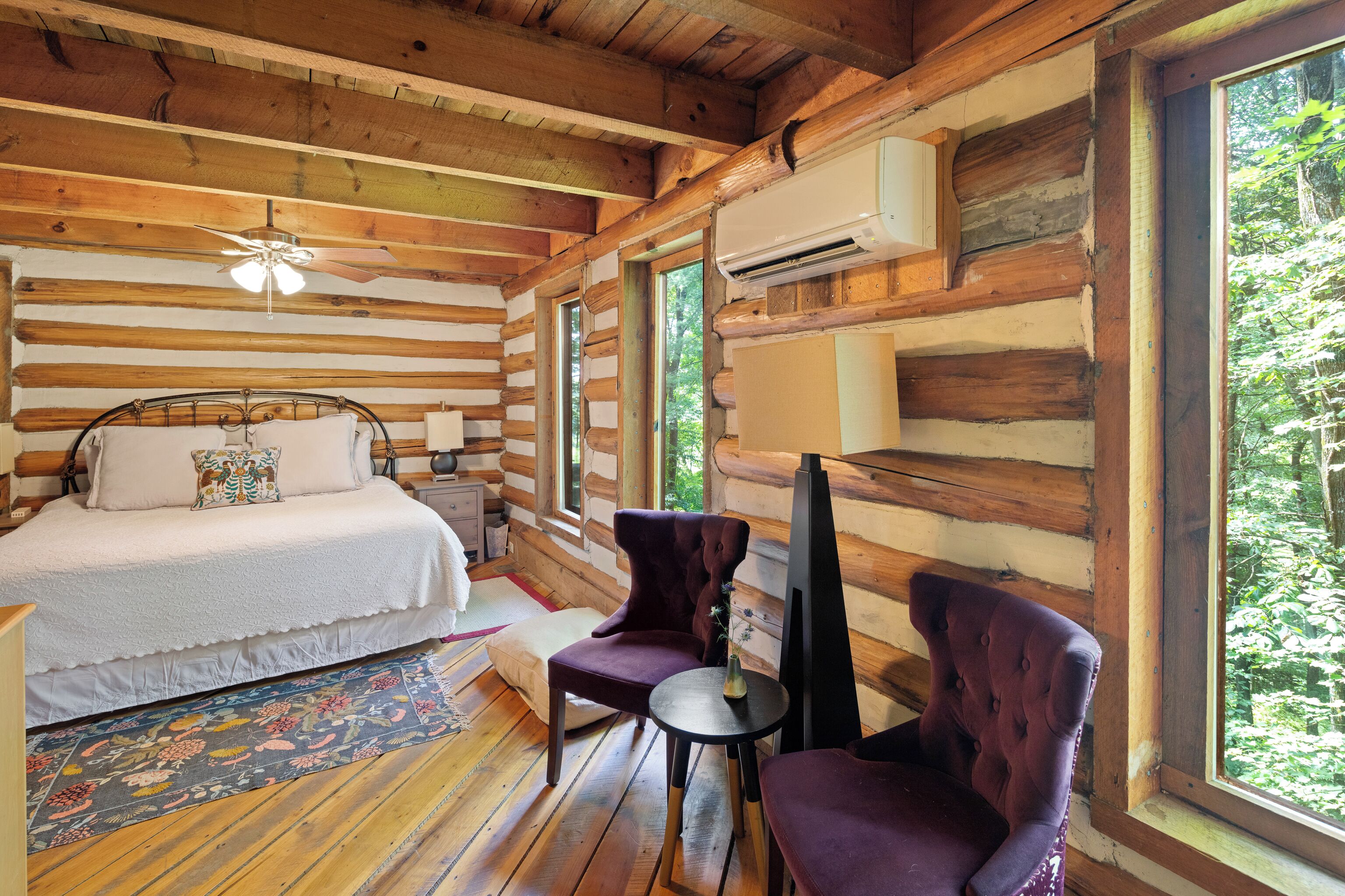Primary bedroom with a view into the forest.