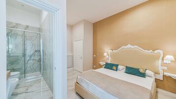 A bedroom with a large bed, a nightstand, and a wall-mounted lamp.