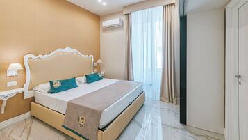 Habitación de hotel con una cama grande, un armario, aire acondicionado y una ventana con cortinas.