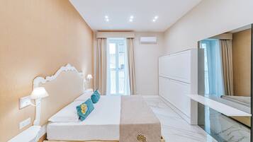 A hotel room with a bed, bedside table, lamp, and a large mirror.
