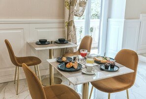 A breakfast setting with a table set for two, featuring plates with pastries, a cup of coffee, and a glass of orange juice. - GENTILE SUITE & SPA VOMERO (Naples)