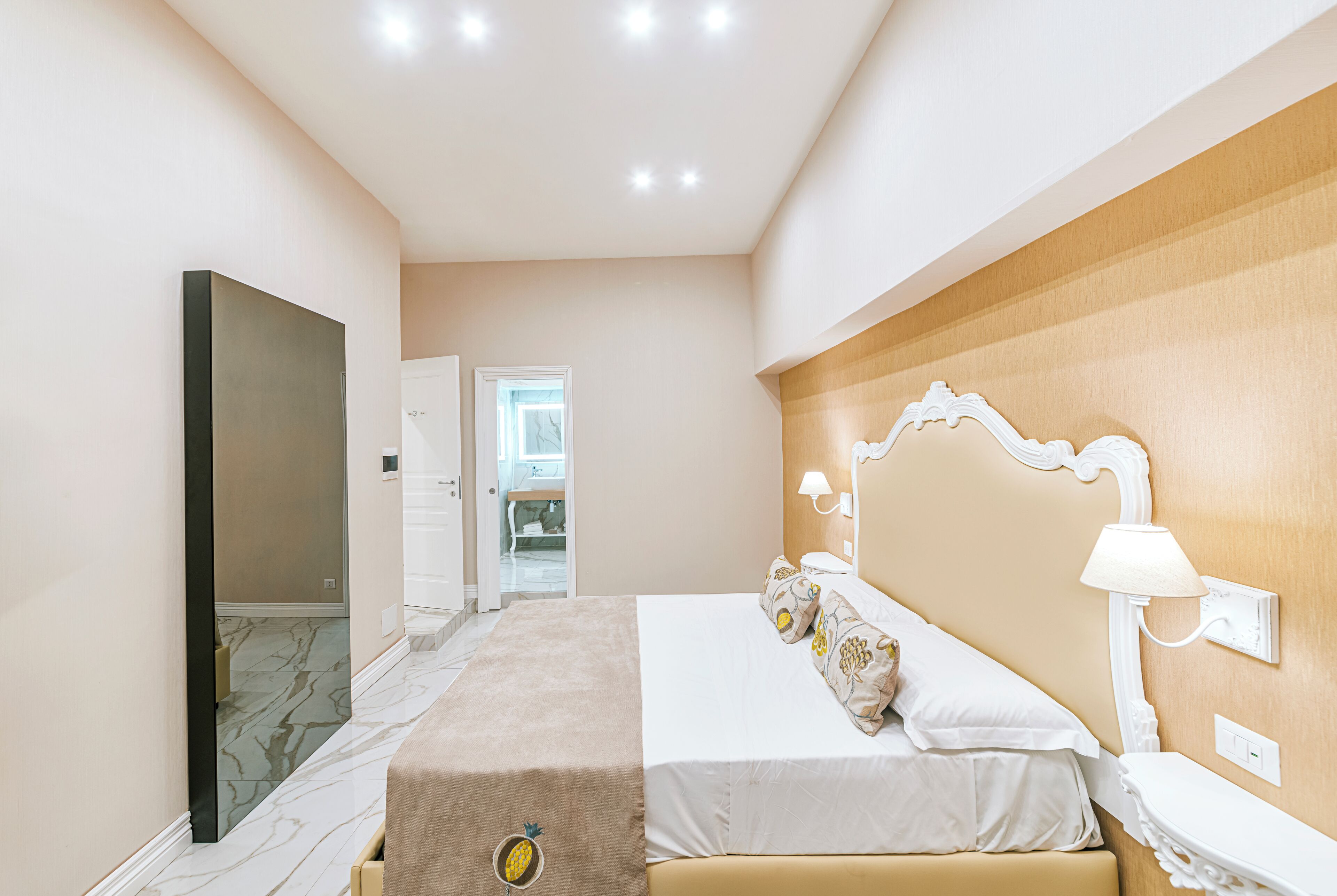 Een moderne slaapkamer met een groot bed, een flatscreen televisie en een houten hoofdbord.