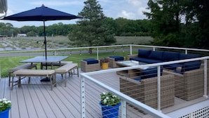A deck with outdoor furniture, including a table, chairs, and a sofa.