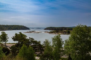Escape to a serene lakeside haven surrounded by lush greenery and rocky outcrops, perfect for relaxation and nature appreciation.